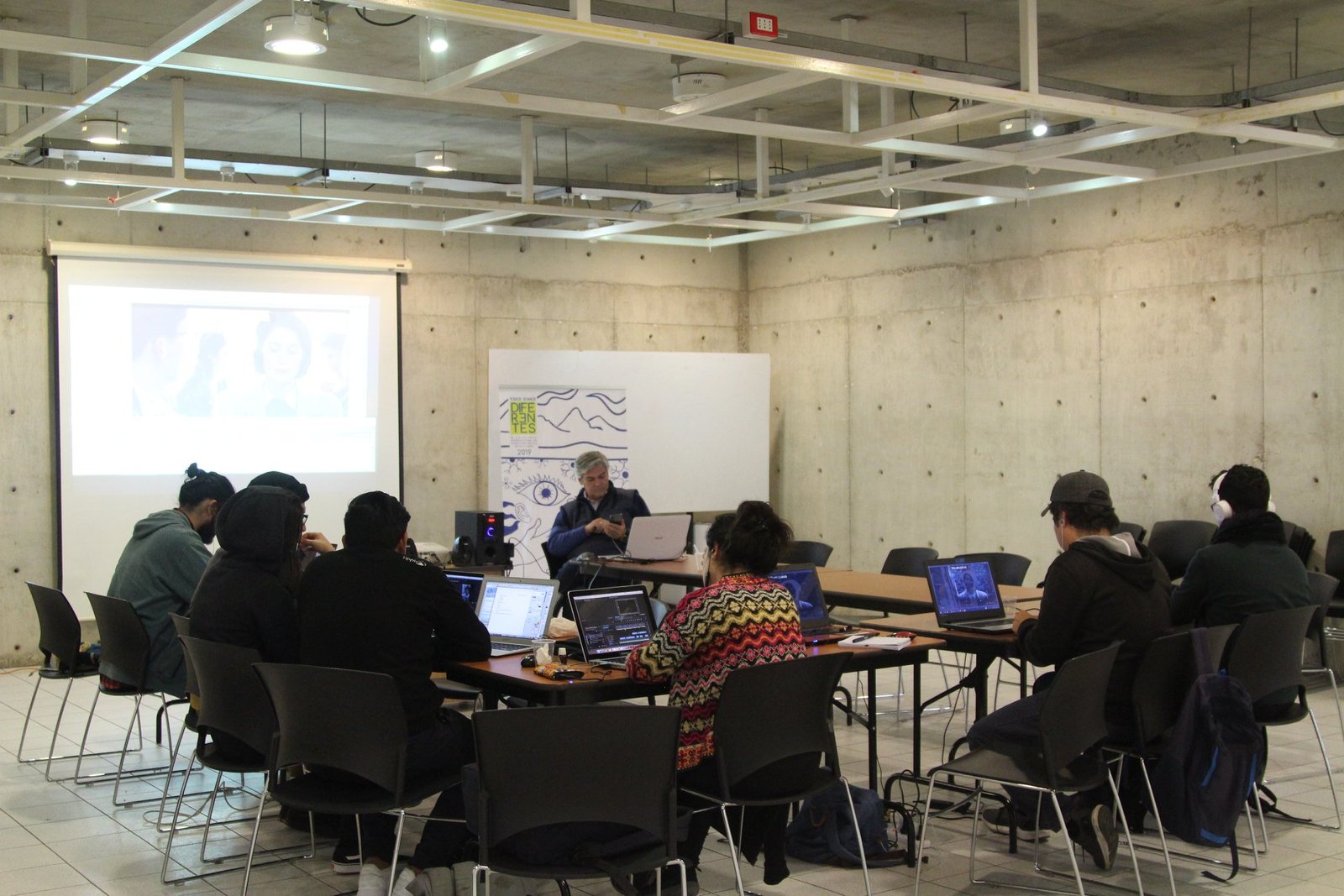 Personas sentadas trabajando en computadores, asistiendo a taller de accesibilidad en la UCN